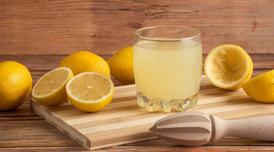 lemons cut with a glass of fresh lemonade